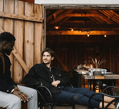 Two people hanging out in a barn